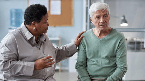 Hospice nurse comforting an older gentleman who appears upset
